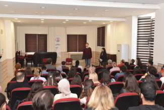 70 - 80 Seyircinin arkasından çekilen fotoğrafta sahnede Ali Alparslan ve Berfin Özgenç sunum yapmakta 